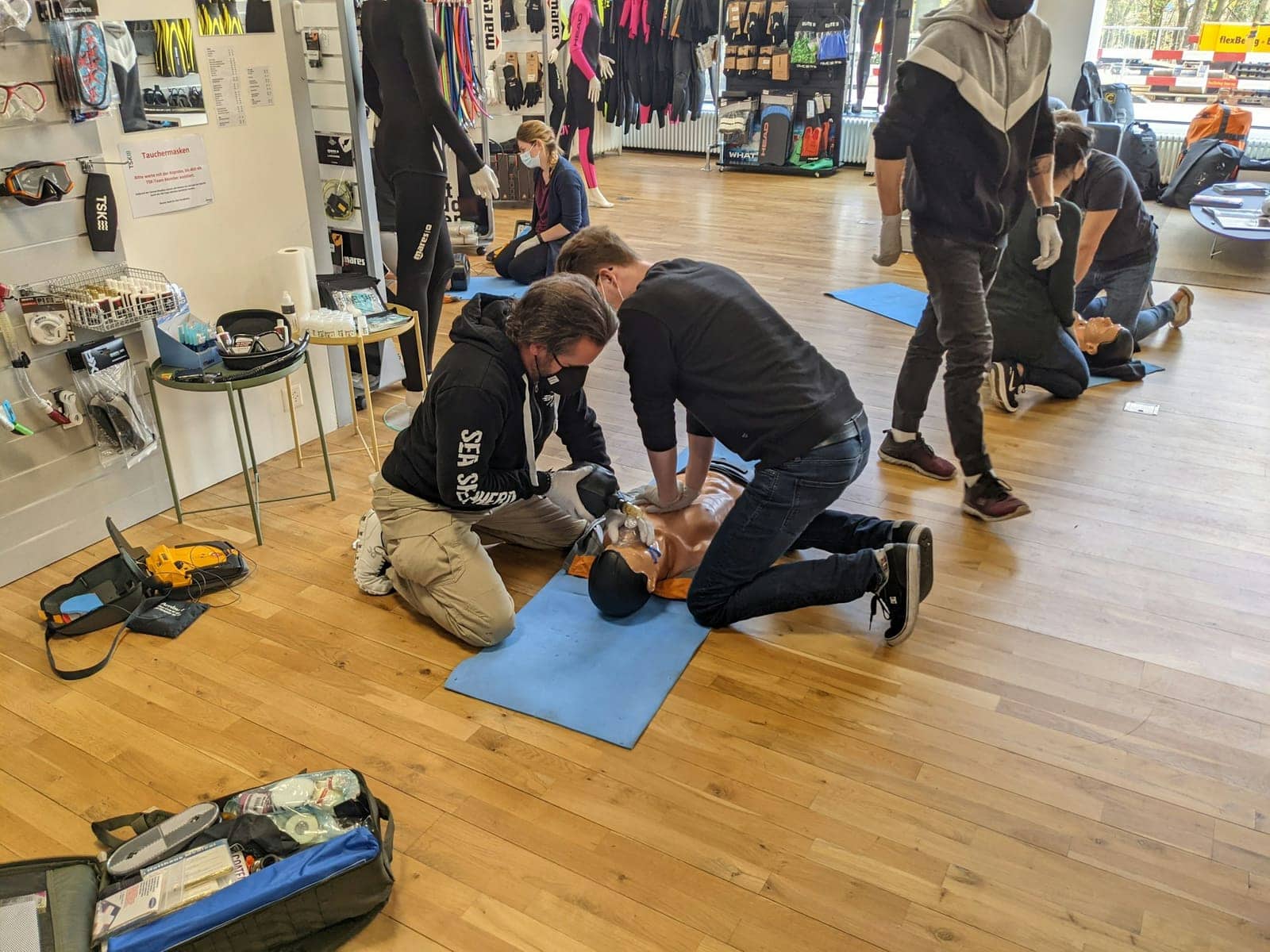 Groupe de stagiaires s'entraînant aux gestes de secours sur des mannequins en salle